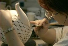 The painter is painting the large tea pot with Cobalt Net pattern